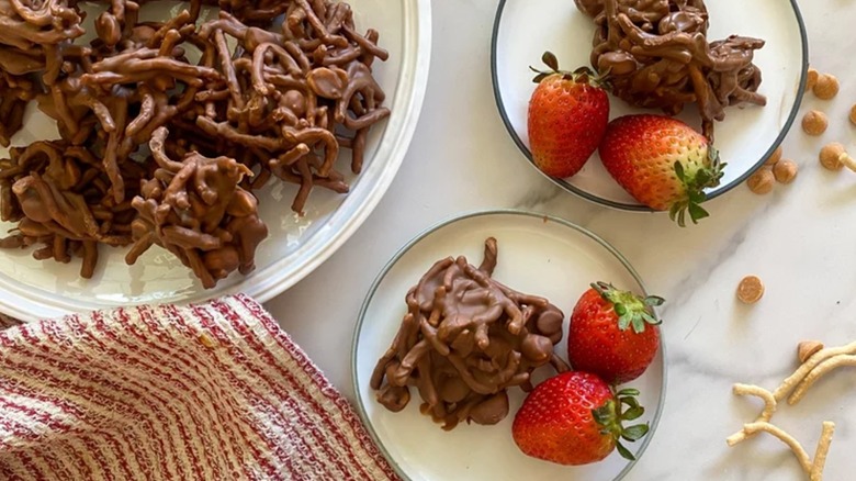 Chocolate and peanut butter haystack cookies on plates with strawberries