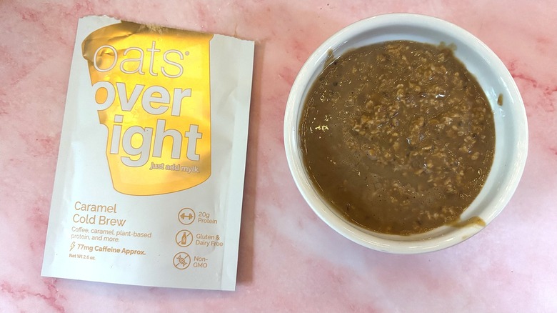 Bowl of Oats Overnight Caramel Cold Brew next to packet on pink surface