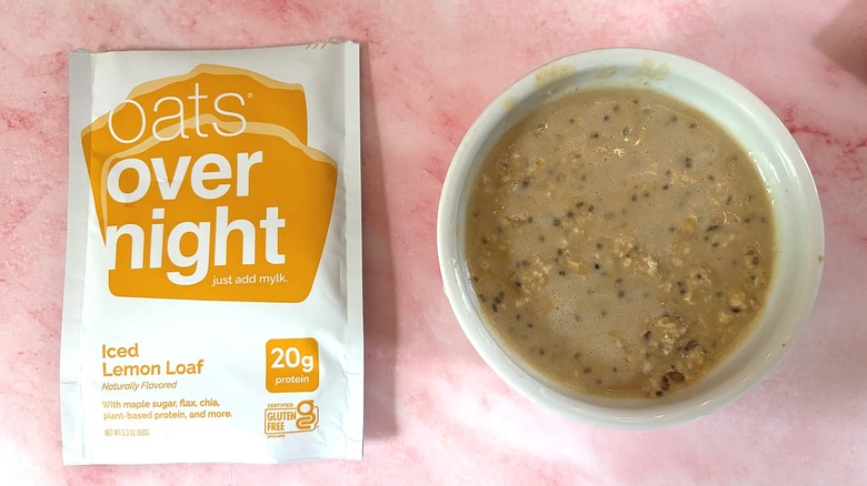 Bowl of Oats Overnight Iced Lemon Loaf next to packet on pink surface