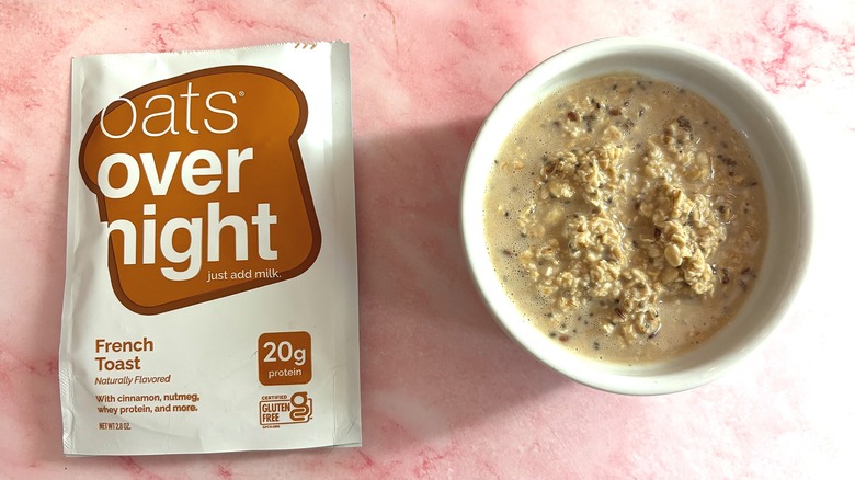 Bowl of Oats Overnight French Toast next to packet on pink surface