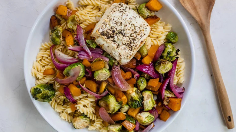 30-Minute Baked Feta Pasta with Roasted Vegetables in white bowl with wooden spoon