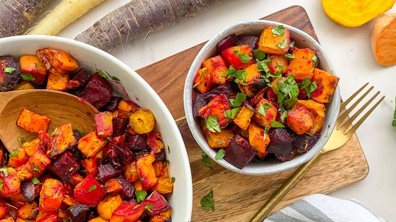 Herbed Roasted Root Vegetables in two white bowls on cutting board