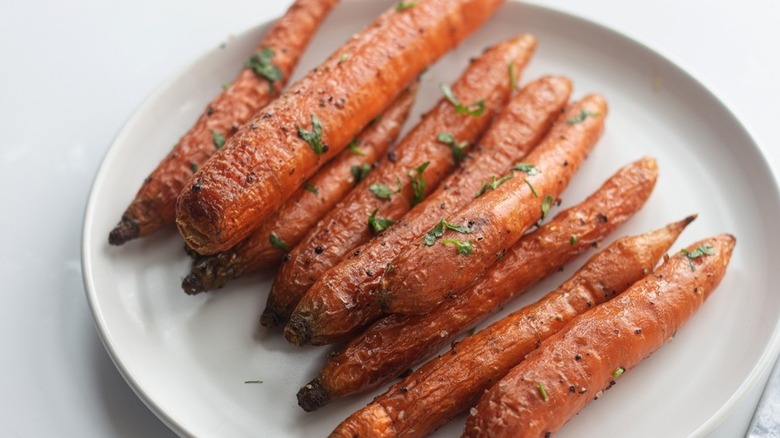 Roasted Carrots on white plate with parsley