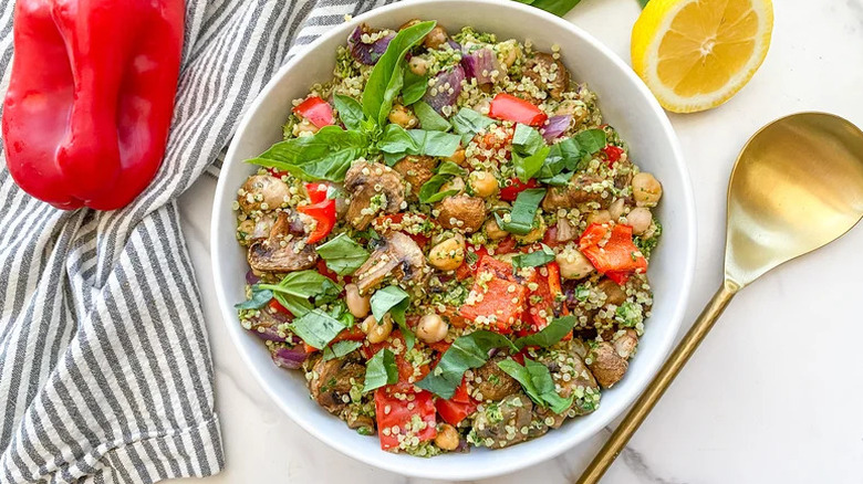 Roasted Veggie Pesto Quinoa Salad in white bowl with gold spoon