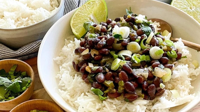 Bowl of black beans and rice with lime wedge