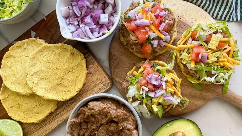 Sopes on cutting board with garnishes