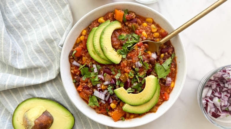 Quinoa chili in bowl with avocado garnish
