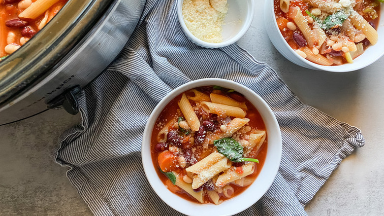 Minestrone soup served into bowls from slow cooker