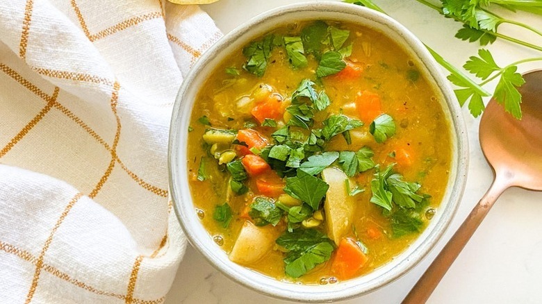 Bowl of split pea soup, garnished with fresh parsley