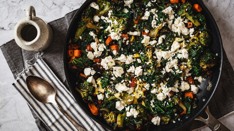 Egg and vegetable scramble in skillet, topped with crumbled feta cheese
