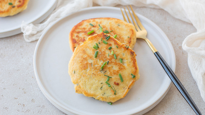 Two Irish potato cakes on plate, garnished with chopped chives