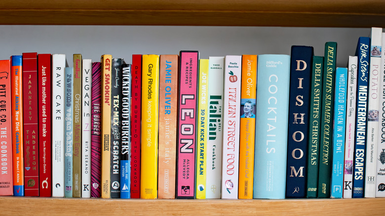 A row of cookbooks on a shelf