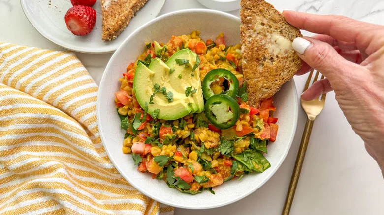 Fluffy, Almost-Eggy Chickpea Scramble in white bowl with piece of bread