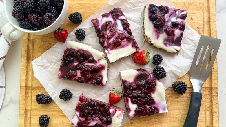Nut-Free Greek Yogurt Granola Bars on wooden cutting board with berries