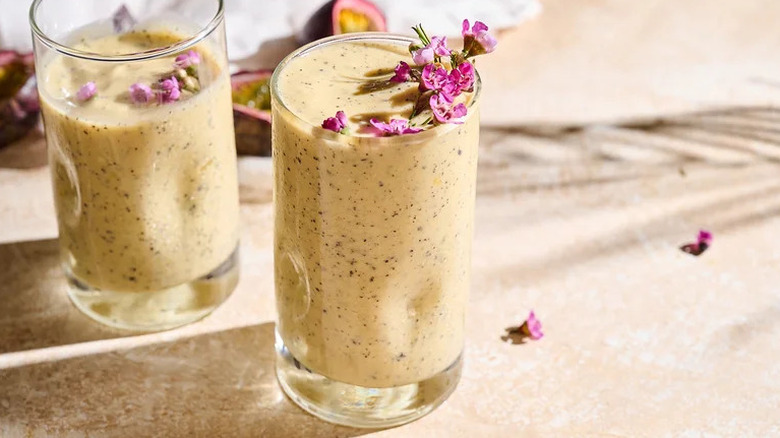 Tropical Passion Fruit Smoothie in two glasses with purple flowers