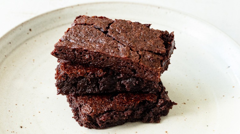 Stack of brownies on white plate