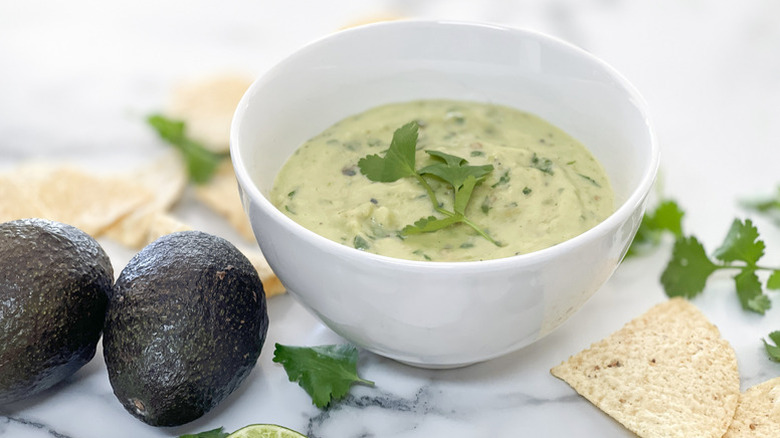 Creamy avocado salsa verde in white bowl