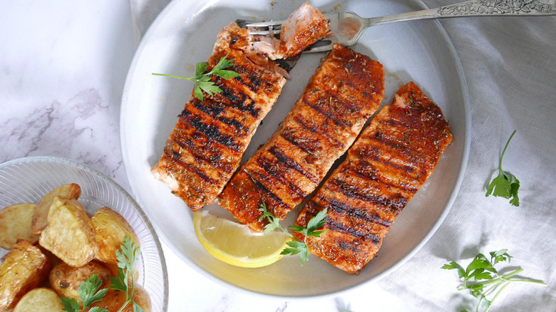 Cajun grilled salmon fillets on plate with lemon wedge