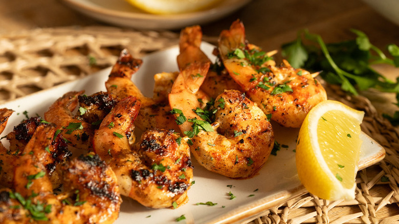 Grilled shrimp on plate with lemon wedge