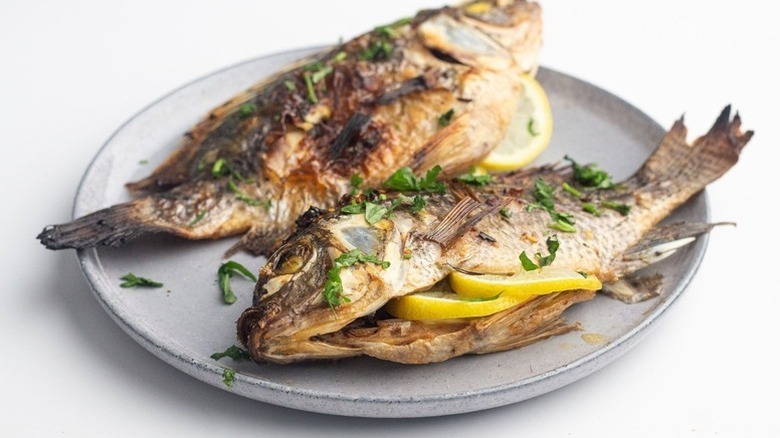 Whole lemon-stuffed grilled tilapia on plate
