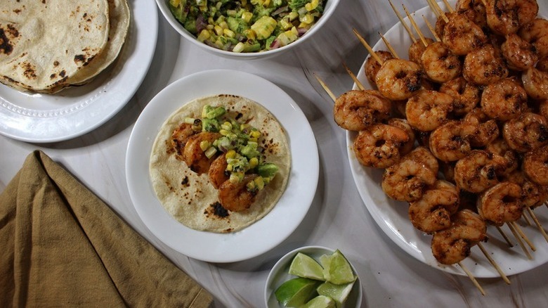 Grilled shrimp tacos served with avocado and corn salsa