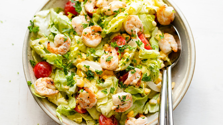 Grilled shrimp salad in bowl with spoon