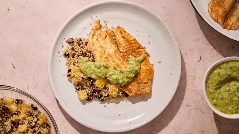 Grilled tilapia on plate with avocado salsa and quinoa