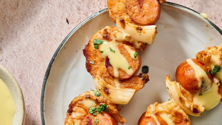 Shrimp and chorizo skewers on plate, drizzled with aioli