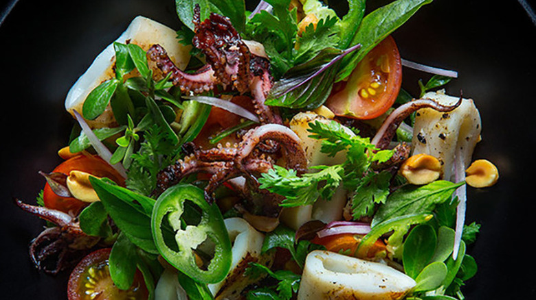 Close up of grilled squid salad with sliced  jalapeños