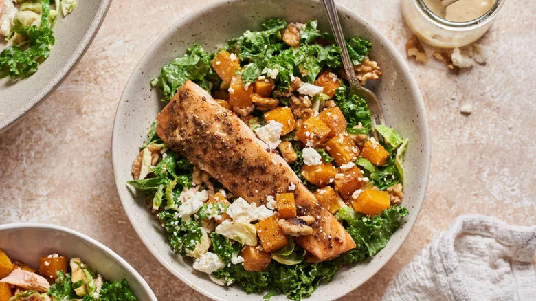 Salmon and Squash Salad with Roasted Pear Dressing in white bowl on table
