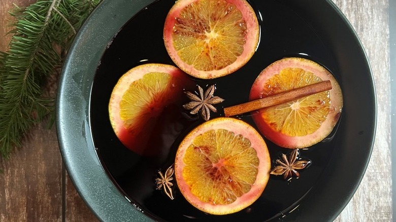 Bowl of mulled wine with orange slices, cinnamon sticks, and star anise