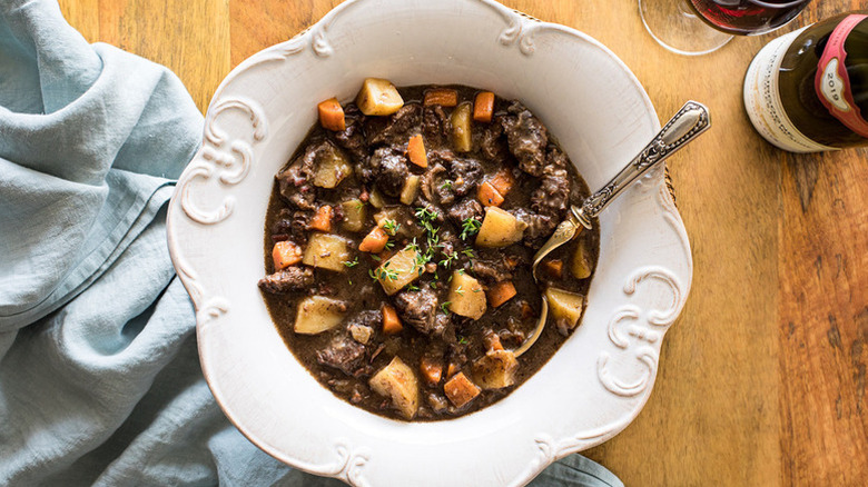 Bowl of beef, potato, and carrot stew with spoon