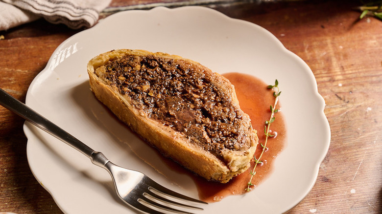 Slice of vegetarian porcini wellington on plate