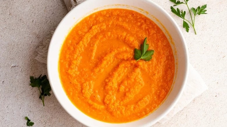 Bowl of carrot ginger soup topped with parsley