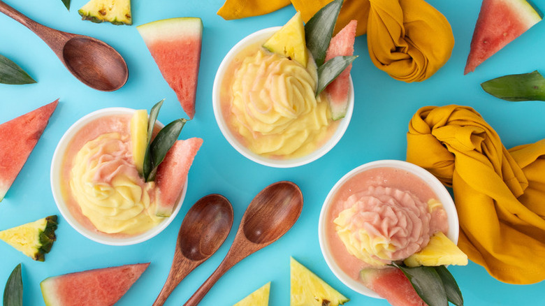 Watermelon and pineapple dole whip in bowls with fresh watermelon and pineapple wedges