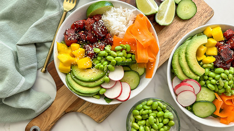 Poke bowls with marinated watermelon, carrot ribbons, edamame, diced mango, and sliced avocado