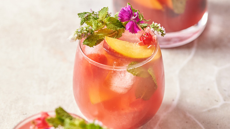 Watermelon sangria in glass, garnished with fresh mint and edible flowers
