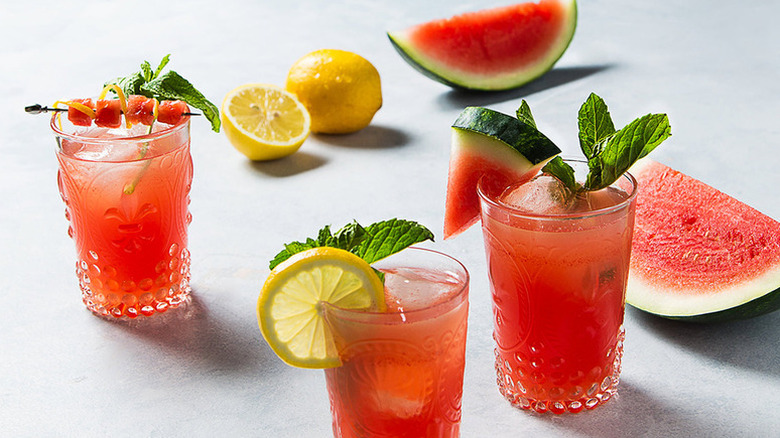 Watermelon lemonade in glasses with garnishes of lemon slices, watermelon wedges, and fresh mint