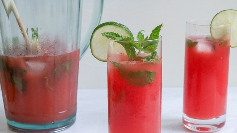 Watermelon mojito cocktails garnished with lime rounds and fresh mint