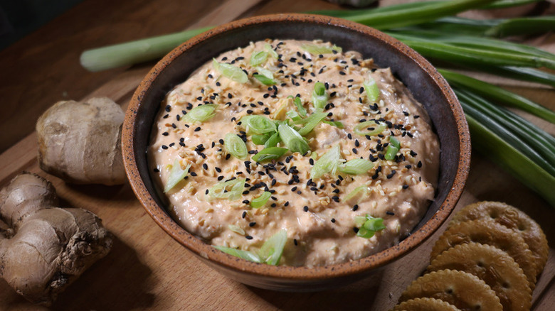 Bowl of salmon dip garnished with sesame seeds and chopped green onion