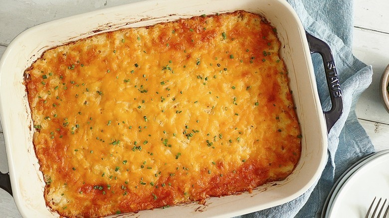 Top view of a cheesy hash brown casserole in baking dish