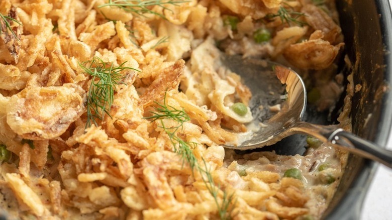 Close up of dilly tuna casserole in baking dish with spoon