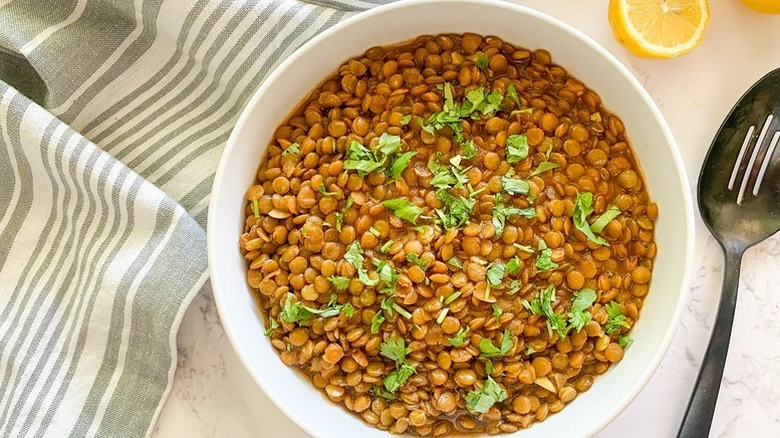 Spiced lentils in white bowl, topped with chopped cilantro