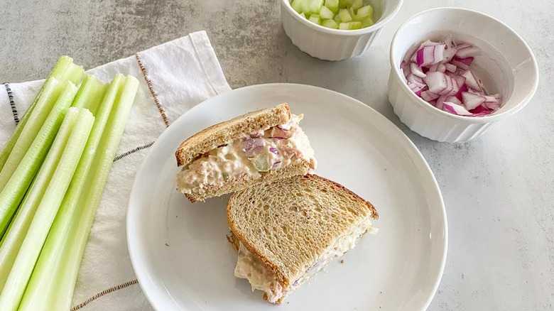 Simple Tuna Salad Sandwich on white plate next to celery sticks