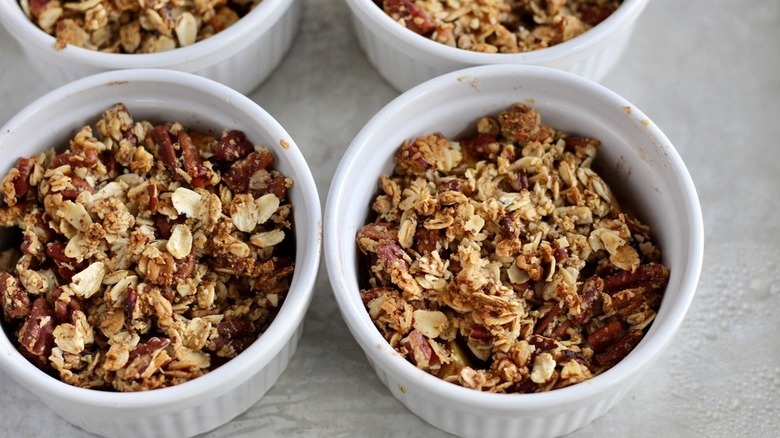 Mini Apple Crumbles in white bowl with apples on countertop