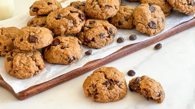 Vegan Chocolate Chip Cookies on parchment paper on wooden cutting board