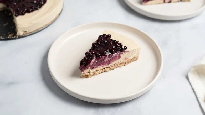 Slice of Vegan No-Bake Blueberry Cheesecake on white plate