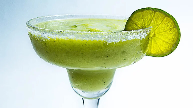 Frozen Margarita with Avocado and Cilantro in margarita glass with slice of lime
