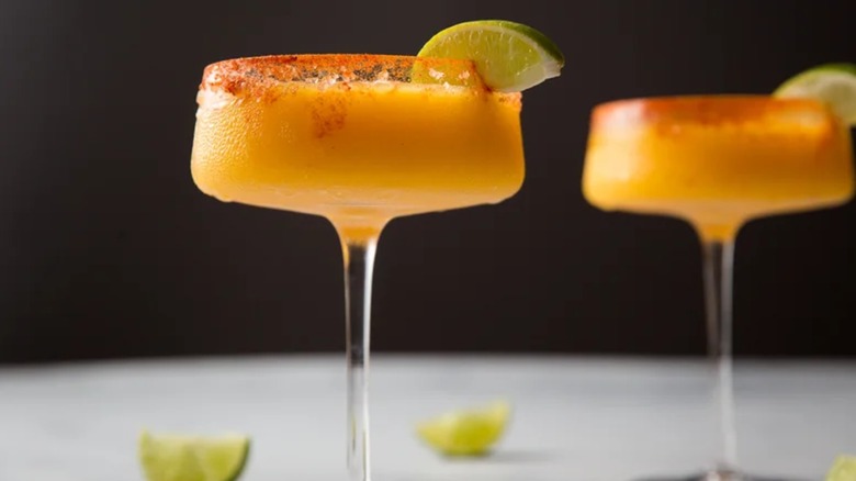 Sip-Worthy Frozen Mango Margaritas in coupe glasses with lime wedges