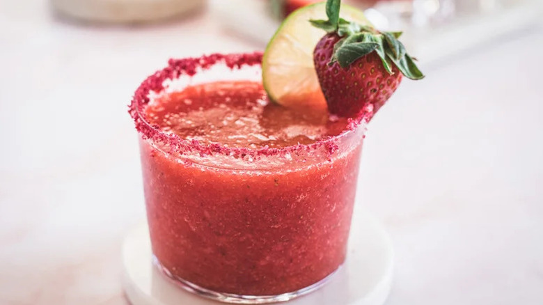 Refreshing Frozen Strawberry Margarita in short glass with strawberry garnish